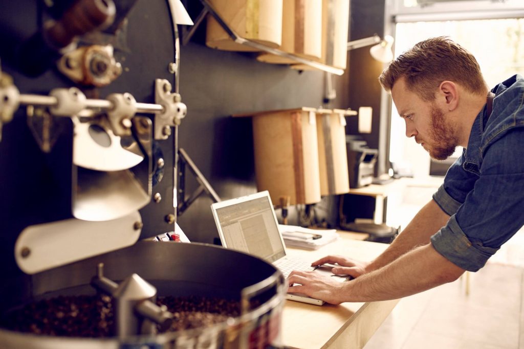 Man on laptop in workshop