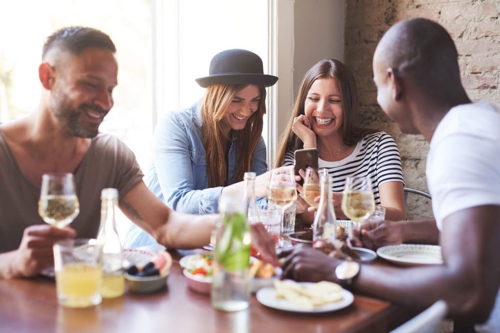 Friends Laughing At Dinner Table