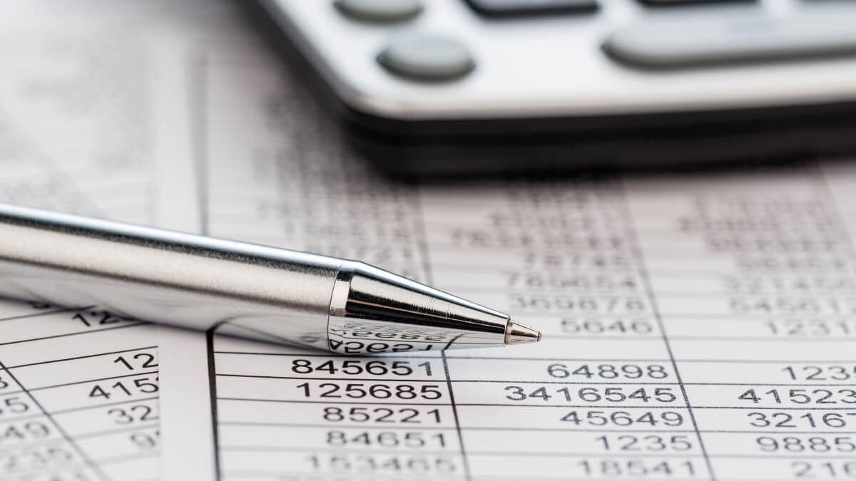 pen over financial spreadsheets