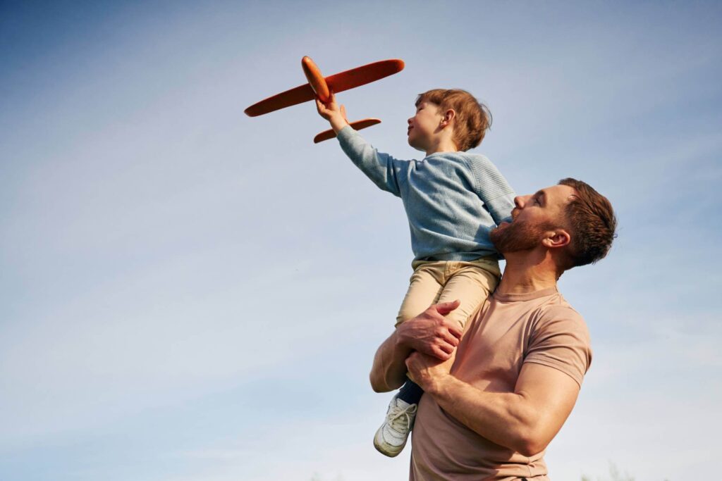 Dad flying plane with young son