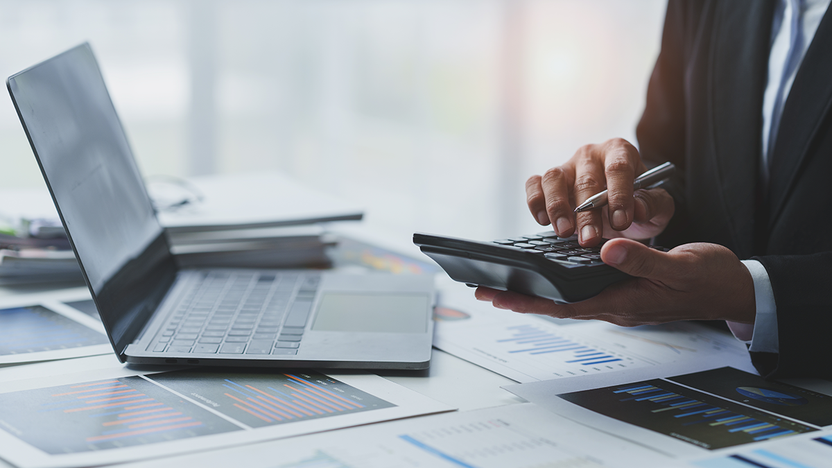 A man typing in a calculator