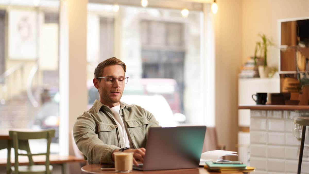 Man on laptop in coffee shop