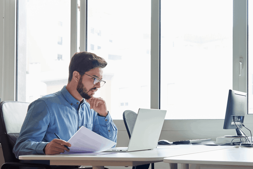 Man on a table looking at laptop screen